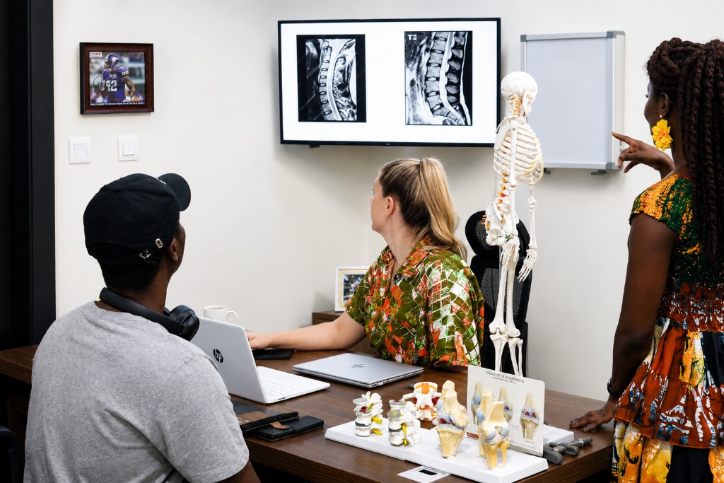 Clinical consultation reviewing spinal imaging for back and neck pain at Spine and Nerve Center Ghana