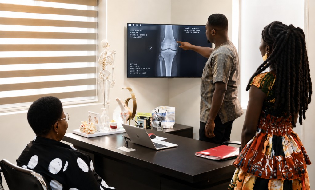 Clinician reviewing a knee X-ray during a consultation at Spine and Nerve Center Ghana